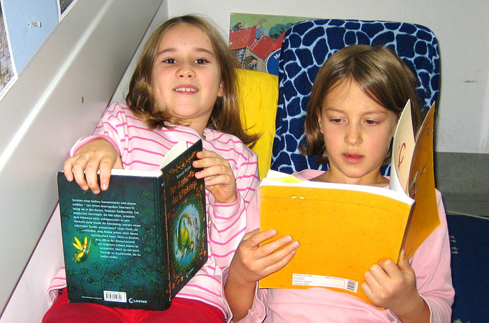 Lesende Kinder auf Schaukelbanane